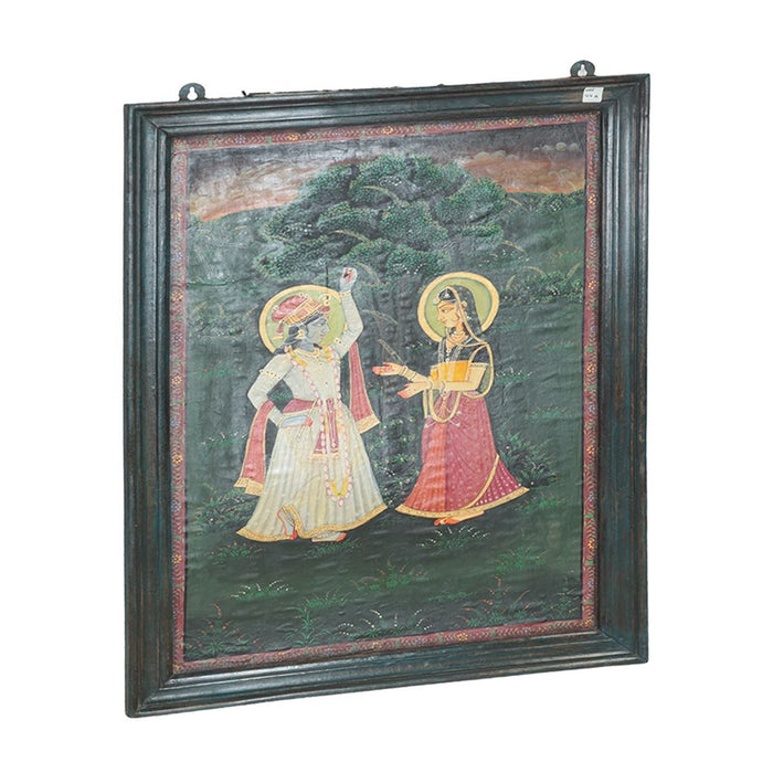 Framed canvas painting of Krishna and Radha in a deep teal reclaimed wood frame with carved detailing, ready to hang